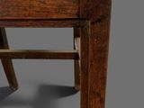 an old wooden chair with a woven seat on a gray background