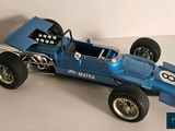 a blue model of a racing car on a white surface