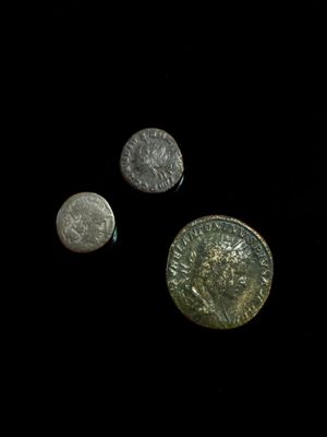 three silver coins sitting next to each other on top of a black surface