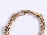 an image of a close up of a gold bracelet on a white background