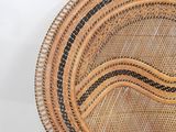 a wicker chair with a black stripe on the seat