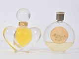 deux flacons de parfum posés l'un à côté de l'autre sur une surface blanche