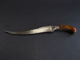 an old knife with a wooden handle on a black surface