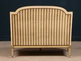 a bed that has a striped headboard on top of it