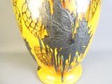 un vase jaune orné d'un motif noir et blanc