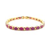 un bracelet en or jaune orné de pierres roses sur fond blanc