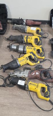 de nombreux outils électriques posés par terre les uns à côté des autres
