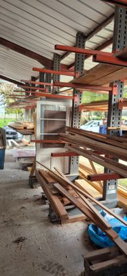 un homme qui se tient devant un rack de bois de construction
