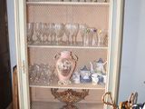 a cabinet with a glass door and a basket on top of it