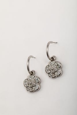 a pair of silver earrings on a white surface