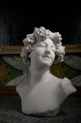 un buste de femme aux cheveux bouclés posé sur une table