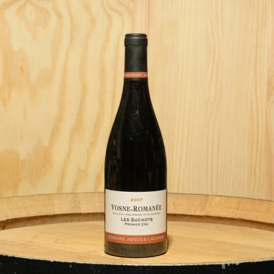 a bottle of wine sitting on top of a barrel
