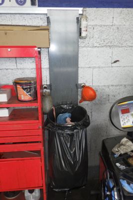 une photo d'un garage avec un établi rouge et une poubelle