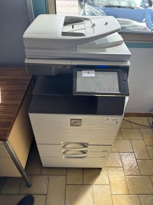 une imprimante posée sur un bureau près d'une fenêtre