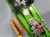 a green toy truck with a big wheel on top of it