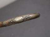 a wooden stick with a metal handle on a table
