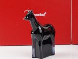 a black horse figurine on a table next to a red box