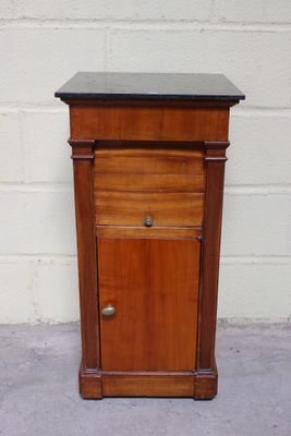 un petit meuble en bois avec un plateau noir
