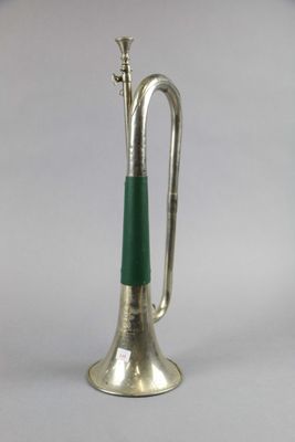 silver trumpet with green handle on a white background