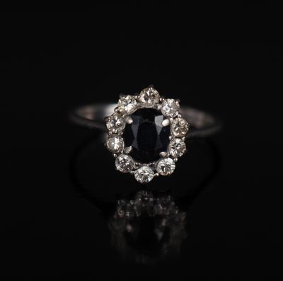 une bague en diamant noir et blanc posée sur une surface noire