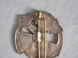 a picture of a silver brooch with a pin on it