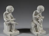 une paire de statues blanches représentant un garçon et une fille assis sur un banc