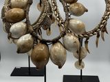 Plusieurs bijoux sont présentés sur des présentoirs posés sur une surface blanche