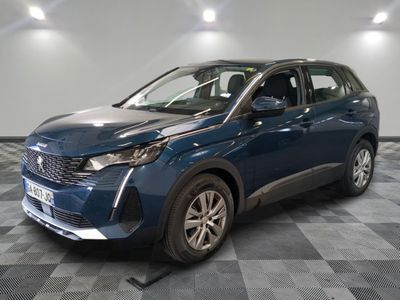 une voiture bleue est garée dans une pièce au sol à carreaux