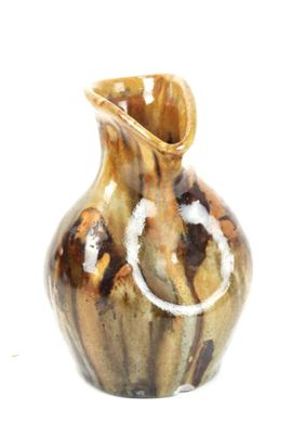 a brown and black vase with a knot on the handle