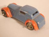 a blue and orange toy car on a white surface