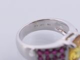 a silver ring with three different colored stones on it