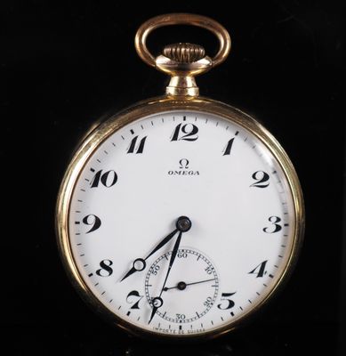 gros plan d'une montre de poche en or sur une surface noire