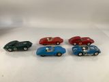 a set of five toy cars are sitting on a white surface