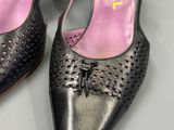 pair of women ' s black leather shoes with holes on the toes