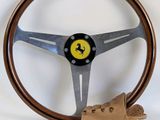 Le volant est en bois et un gant en cuir est posé à côté.