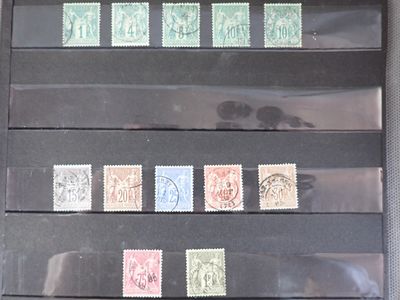 cinq timbres différents sur une feuille de papier noir
