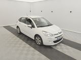 voiture blanche garée dans un garage dont le sol est à carreaux noirs et blancs
