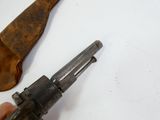 a person holding a small revolver next to a piece of leather