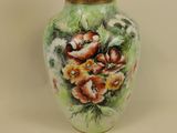 a small vase with flowers painted on it on a table