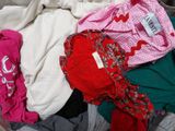 a pile of clothes sitting on a bed with a label on it