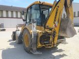 a yellow backhoe of a construction vehicle parked in a parking lot