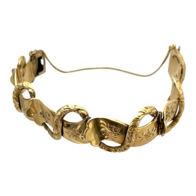 bracelet en or orné de deux têtes de mort et d'un serpent sur fond blanc