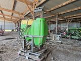 un grand réservoir vert posé sur une palette à l'intérieur d'un bâtiment