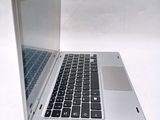 a silver laptop with a black keyboard on a white surface