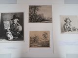 three framed pictures of a man holding a map and a woman holding a skull