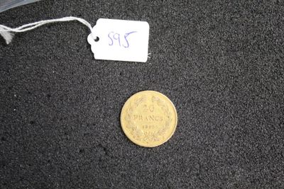 a small coin sitting on the ground next to a piece of luggage