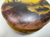 a small box with a painting on it on a table