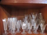 a wooden shelf with a bunch of wine glasses on it