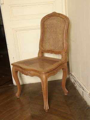 a wooden chair sitting in front of a white door