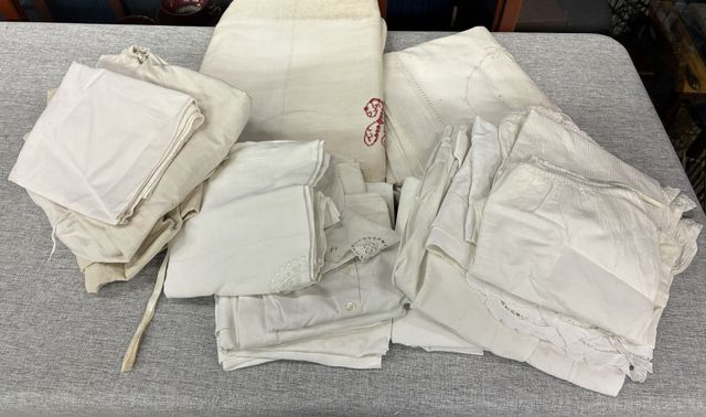 Une caisse de linge : draps et vêtements. Vendu en l’état sans vé